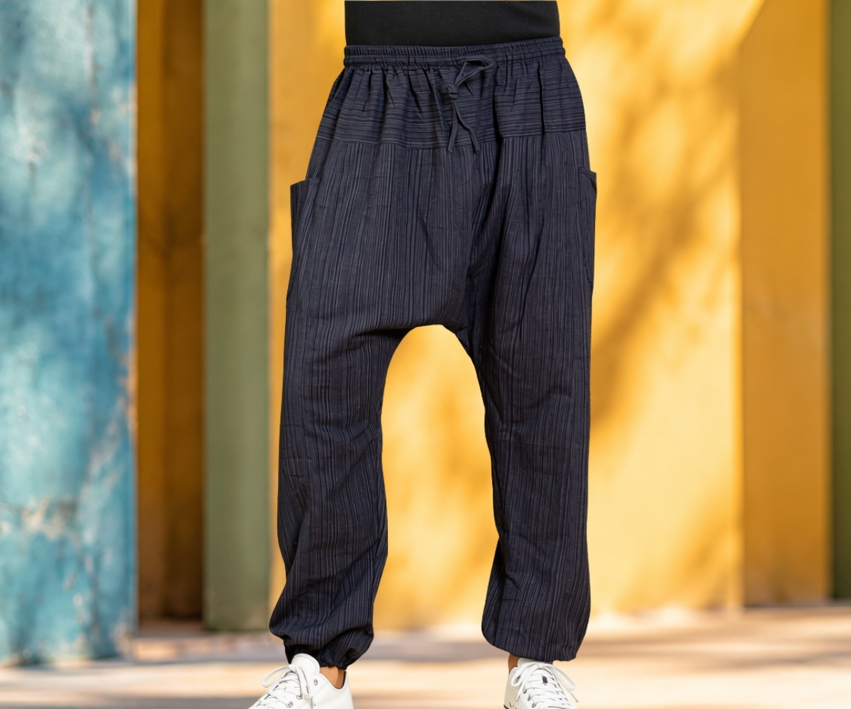 Model wearing dark blue harem trousers with fine stripes, dropped crotch and elasticated waistband
