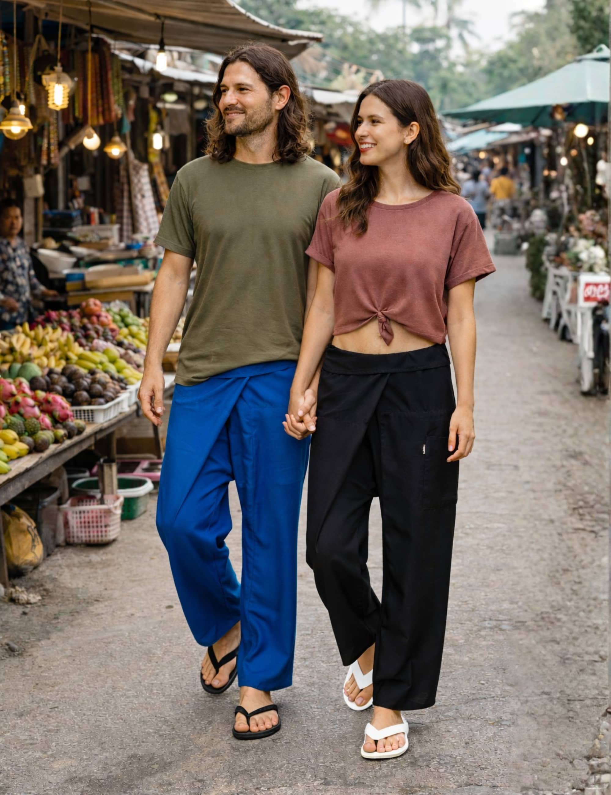 Paar trägt Thai Fischerhosen auf einem Markt in Royalblau und Schwarz, Unisex Wickelhosen aus Viskose, weiter Schnitt mit Wickeltechnik, geeignet für Alltag und Reisen