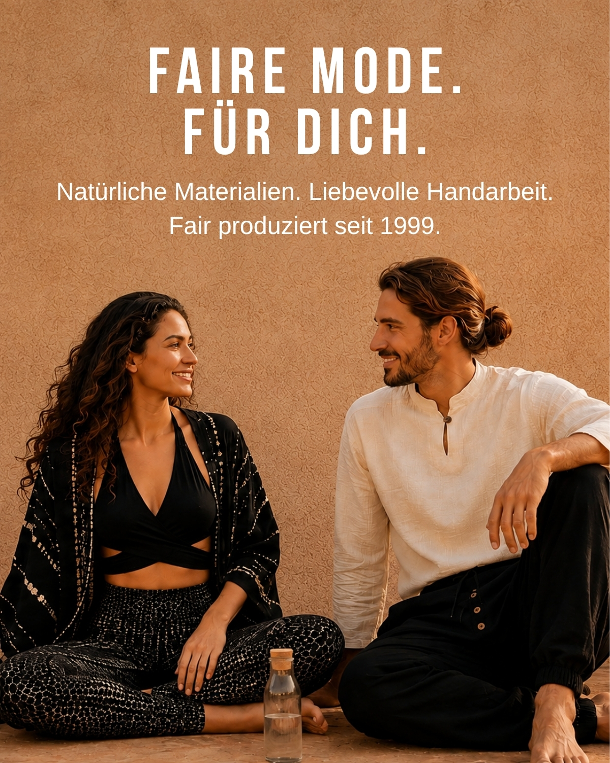 Zwei Models in fair produzierter Mode aus natürlichen Materialien, sitzend vor warmer Wand mit Markenbotschaft zur nachhaltigen Handarbeit seit 1999