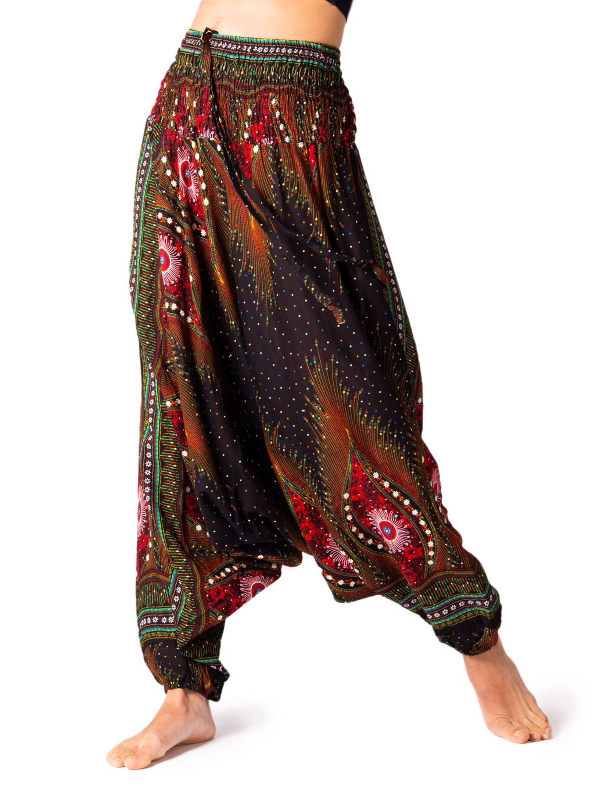 Model trägt die PANASIAM Aladinhose Peacock, eine luftige Boho-Yogahose mit weitem Schnitt, elastischem Bund und farbigem Pfauenmuster für Tanz, Meditation und Freizeit.