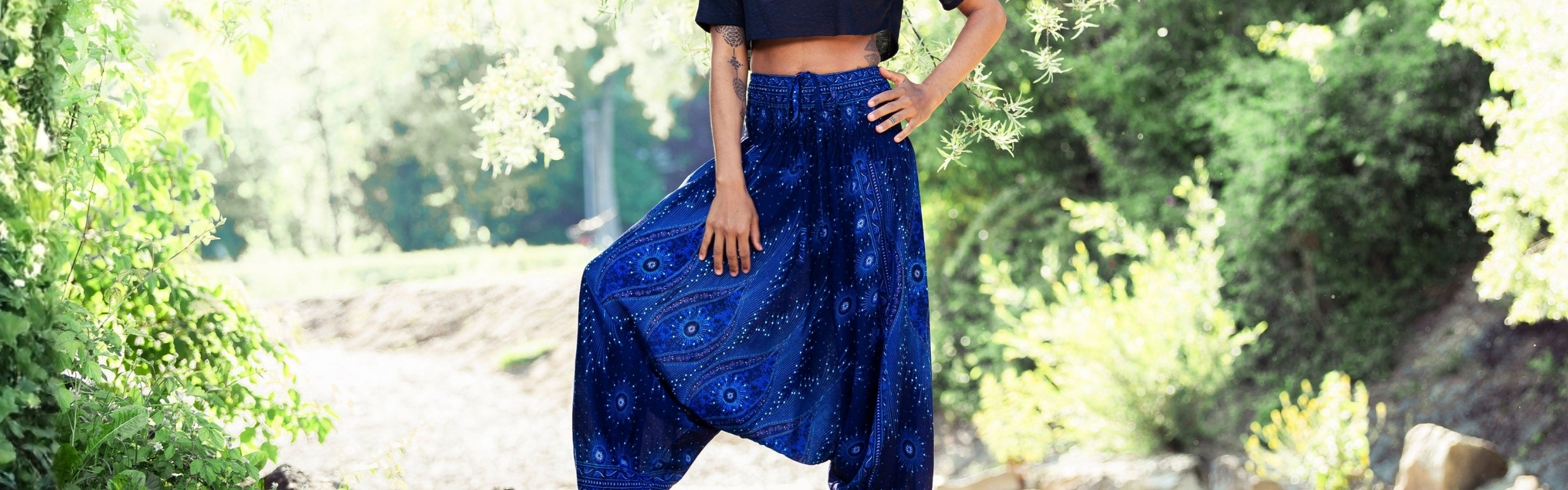 Model trägt eine dunkelblaue Haremshose mit Mandala-Muster und elastischem Bund im Boho-Stil im Freien