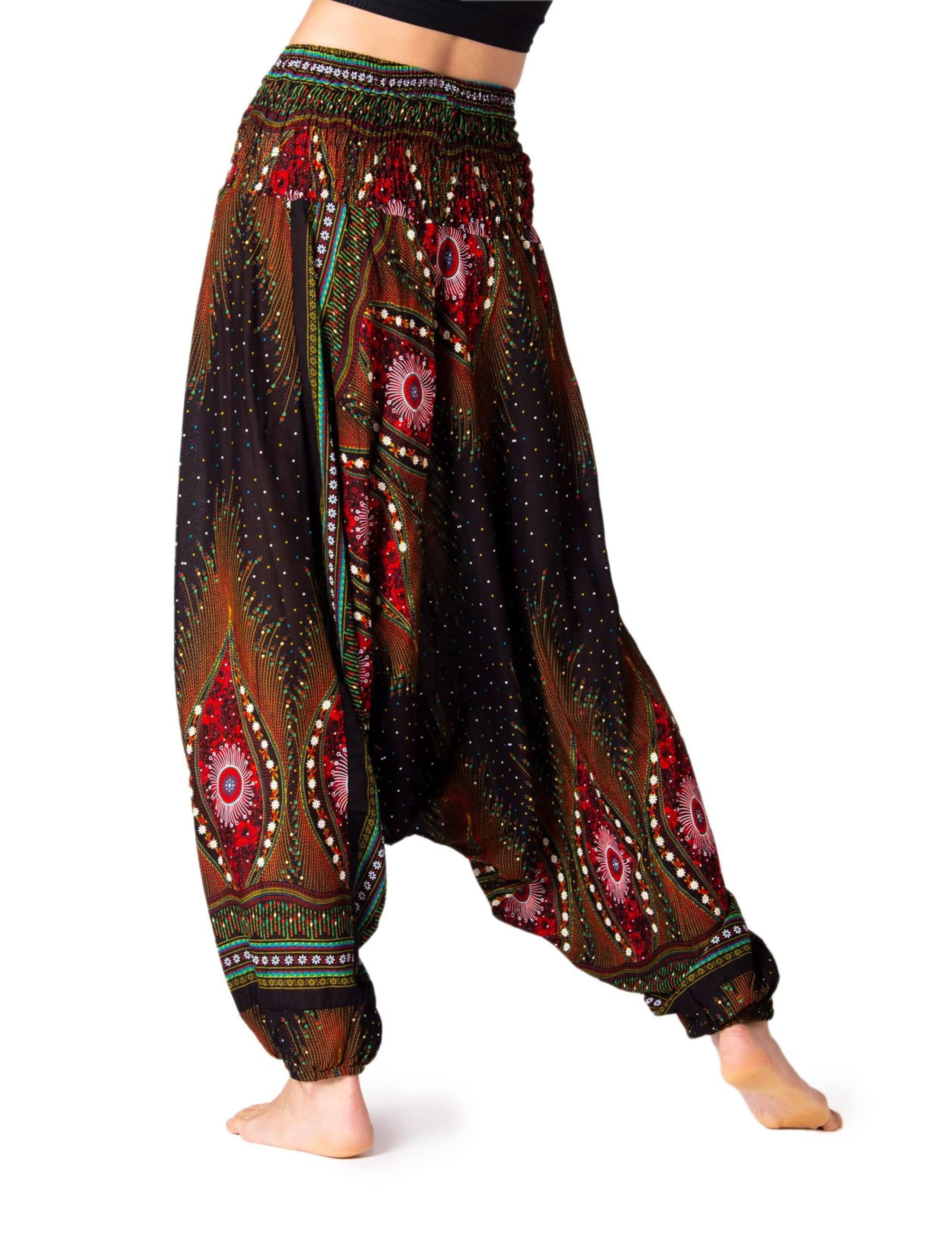 Model trägt die PANASIAM Aladinhose Peacock, eine luftige Boho-Yogahose mit farbigem Pfauenmuster und bequemem, weitem Schnitt.