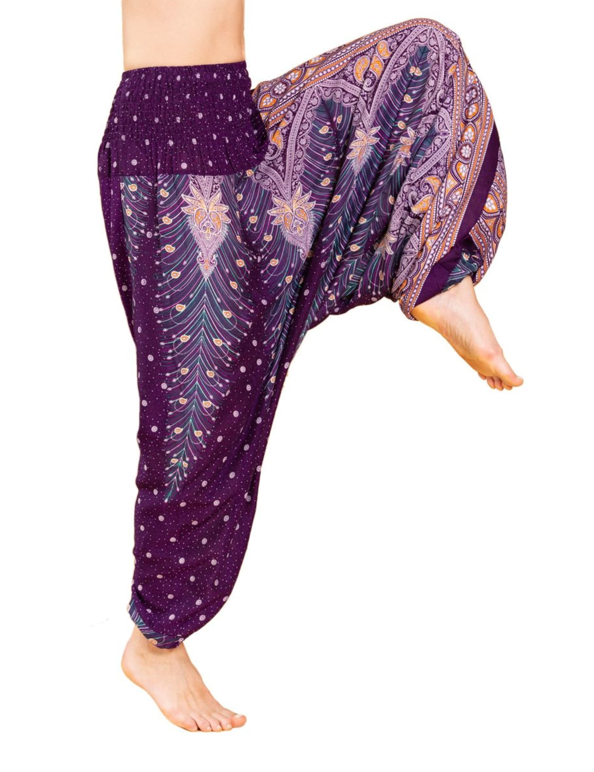 Model trägt die Aladinhose Peacock von PANASIAM in Violett mit Pfauenmuster – luftige, atmungsaktive Boho-Yogahose und Tanzhose für Damen.