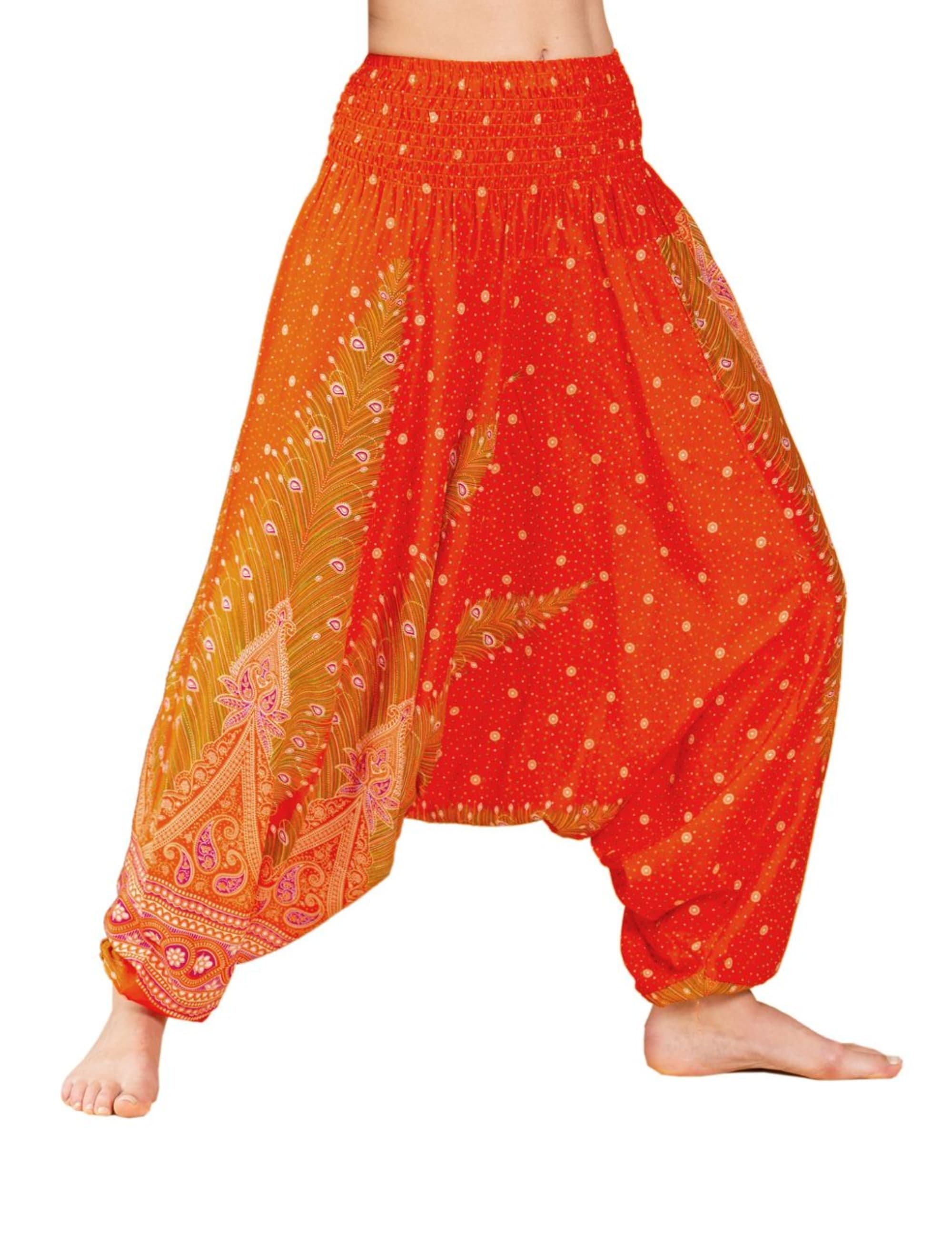 Model trägt die PANASIAM Aladinhose Peacock, eine luftige orange Boho-Yogahose mit Pfauenmuster, weitem Schnitt und elastischem Bund – ideal für Yoga, Tanz, Meditation und Freizeit.