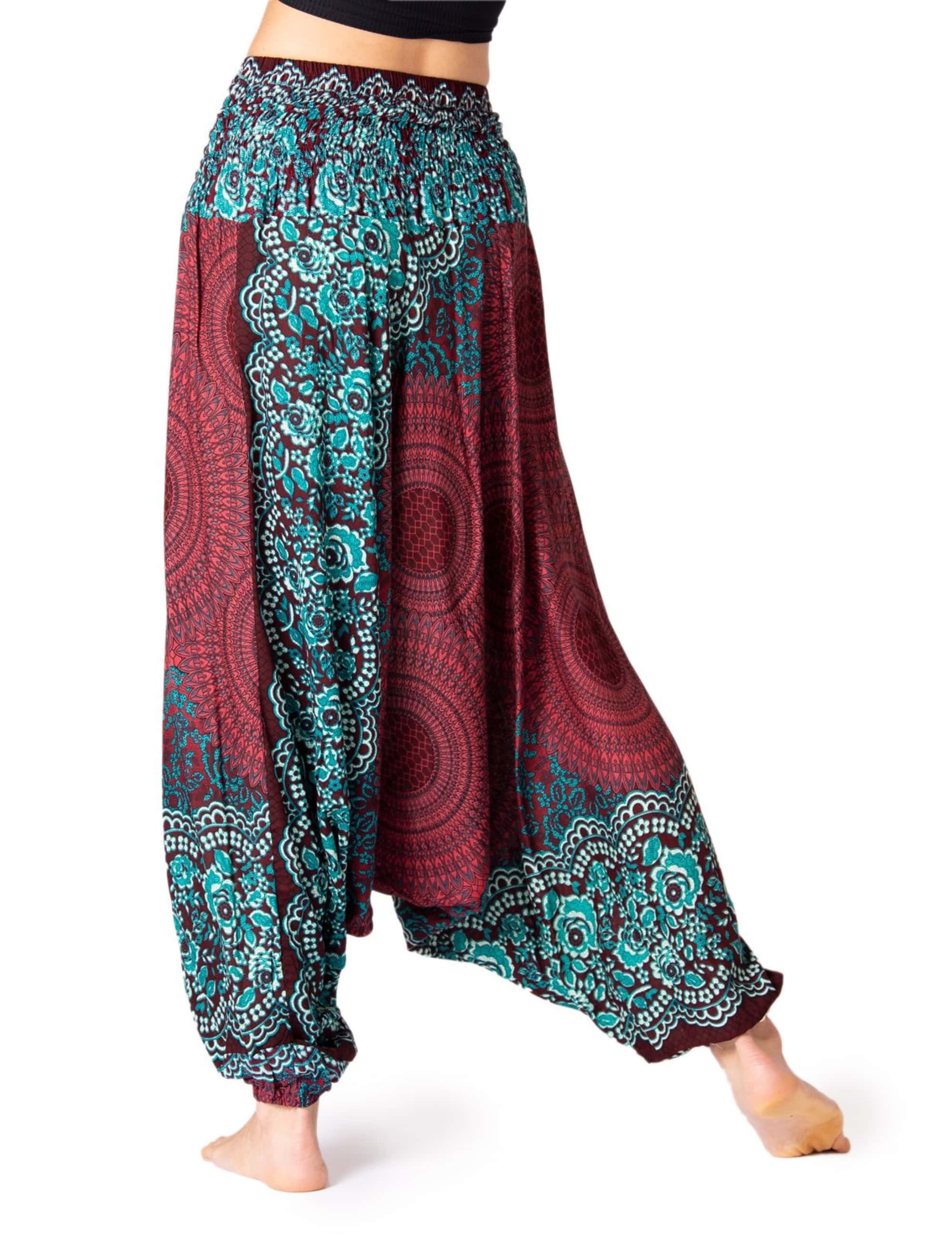Model trägt die Aladinhose Peacock von PANASIAM mit lockerem Schnitt und türkis-bordeauxfarbenem Muster – bequeme, atmungsaktive Damen-Yogahose im Boho-Stil für Yoga, Tanz und Freizeit.