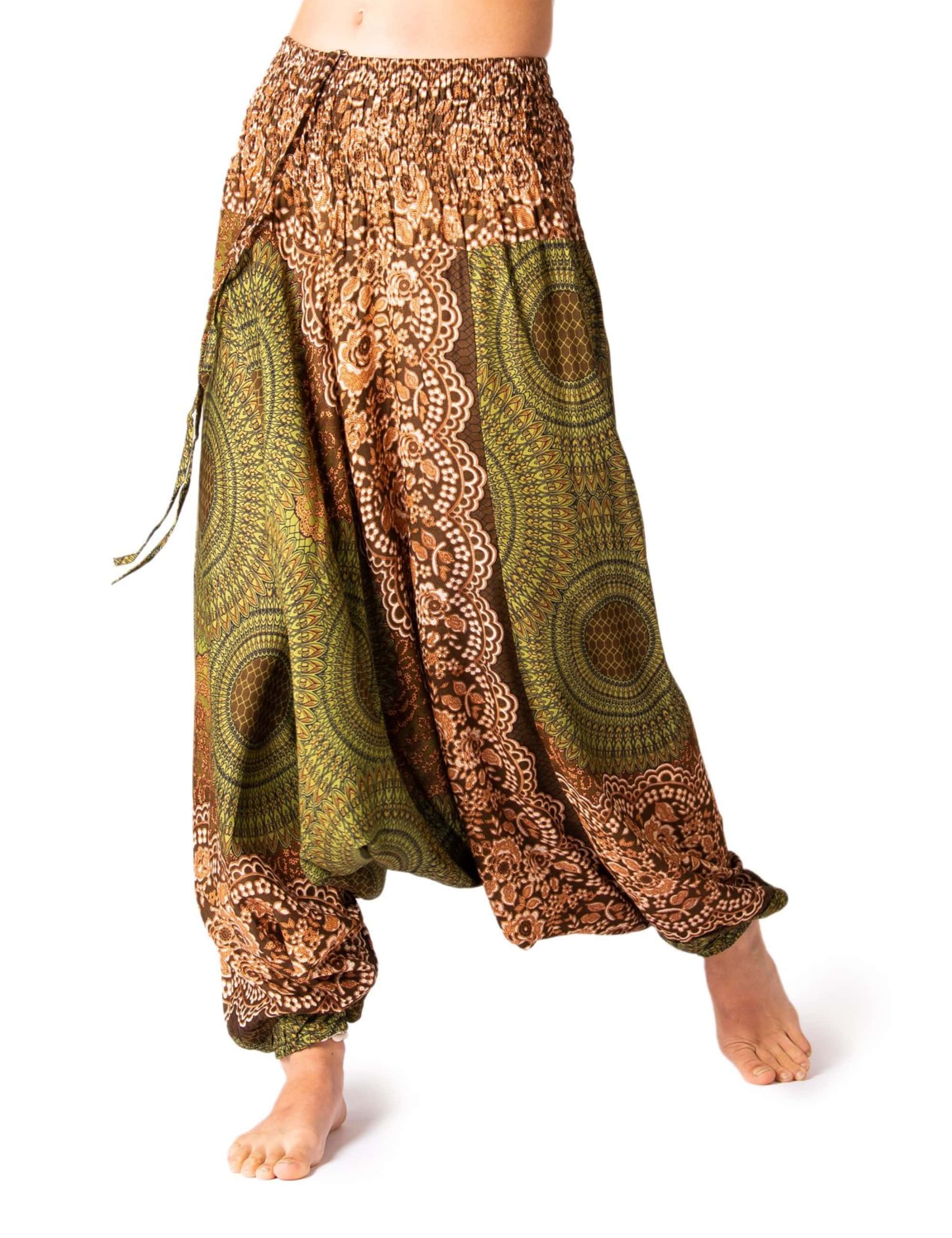 Model trägt die PANASIAM Aladinhose Peacock, eine luftige Boho-Yogahose für Damen mit elastischem Bund und grün-braunem Pfauenmuster, ideal für Yoga, Tanz und Freizeit.
