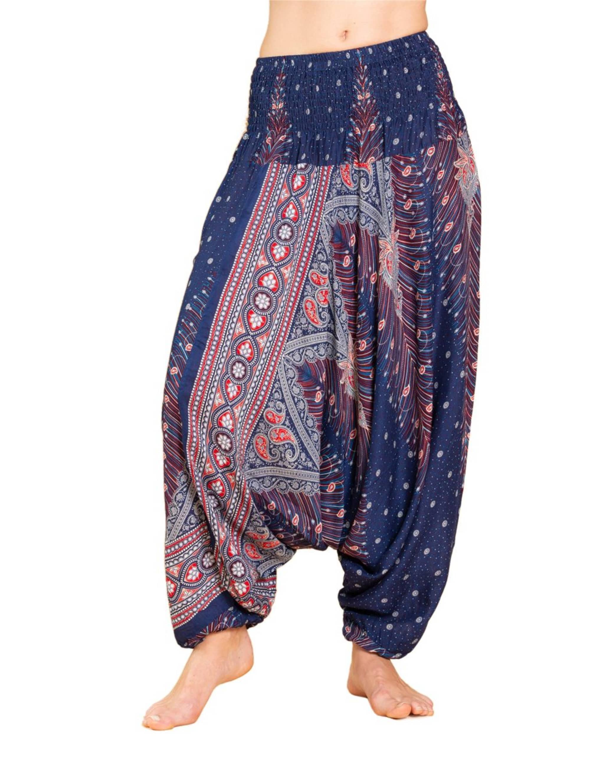 Model trägt die Aladinhose Peacock von PANASIAM: locker fallende, atmungsaktive Boho-Yogahose in Blau mit Pfauen- und Paisleymuster, ideal für Yoga, Tanz, Meditation und Freizeit.