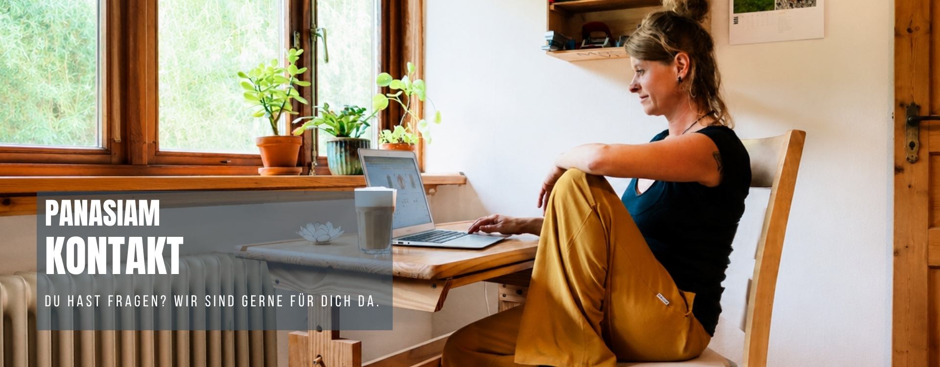 Kontaktseite von Panasia: Frau sitzt am Laptop im hellen Homeoffice am Fenster, Symbolbild für Kundenservice und Beratung