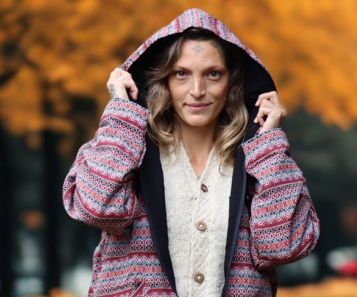 Frau trägt eine gemusterte Damen Hoodie-Jacke mit Kapuze im Ethno-Design vor herbstlichem Hintergrund