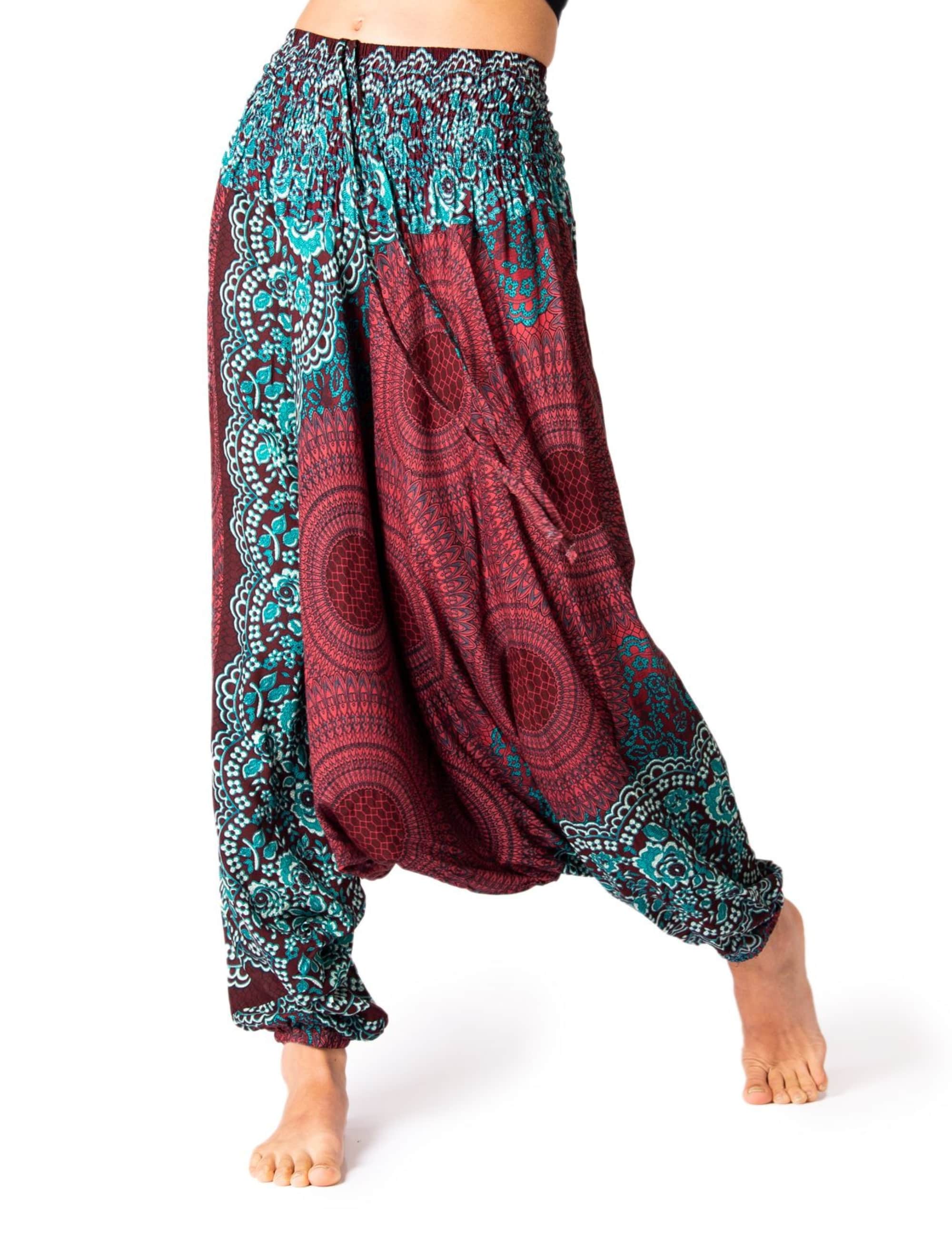 Model trägt die PANASIAM Aladinhose Peacock, eine luftige Boho-Yogahose mit elastischem Bund und orientalischem Pfauenmuster in Türkis und Bordeaux.